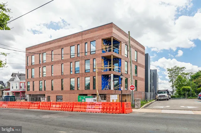 a city street lined with tall buildings and a yard