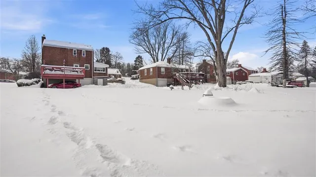 a view of a covered with snow in back yard