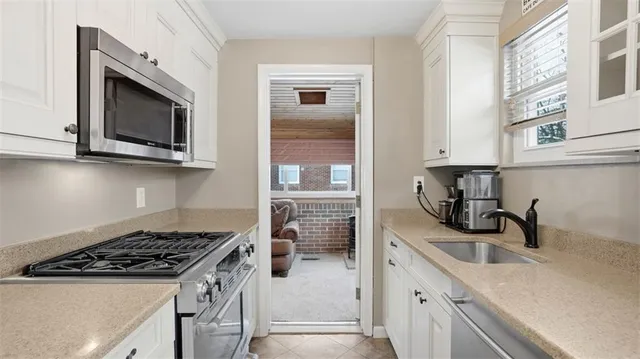 a kitchen with cabinets stainless steel appliances and a sink