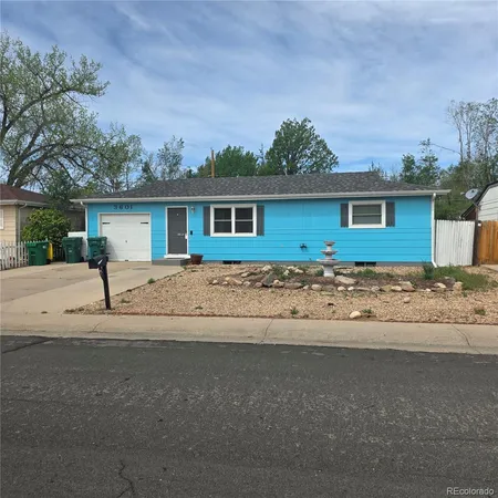 a front view of house with yard and trees around
