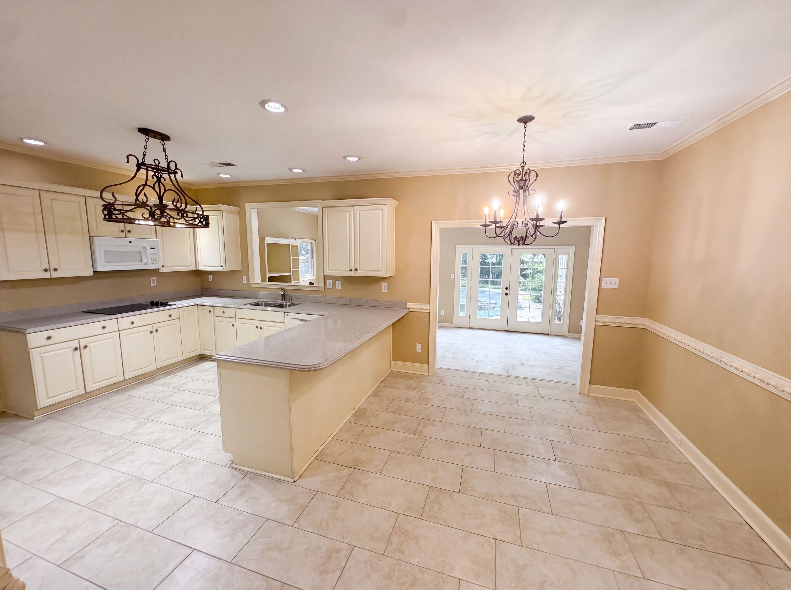 9424 Gotten Road Germantown, TN 38139 - Photo 2 of 27 Spacious kitchen featuring cream cabinetry, light-toned countertops, and an integrated microwave