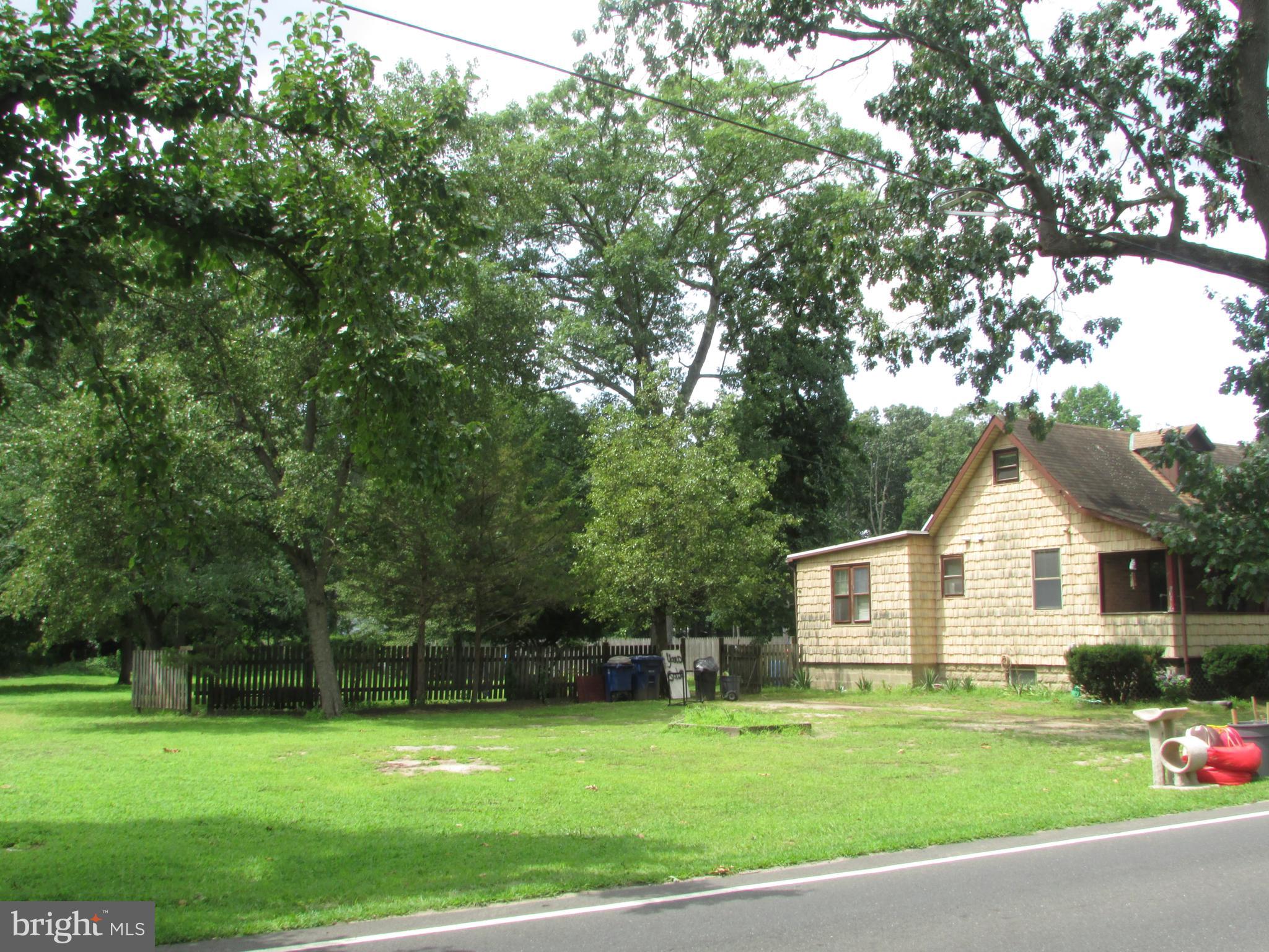 1215 Bridgeboro Road Edgewater Park, NJ 08010 - Photo 2 of 13 a view of a white house in front of a big yard with plants and large trees