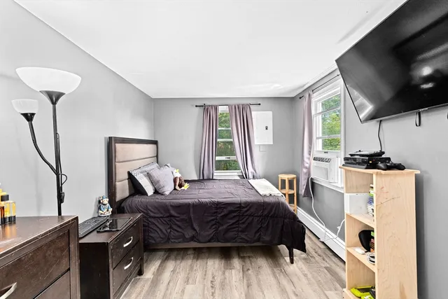 a bedroom with a bed and a flat tv screen on the dresser