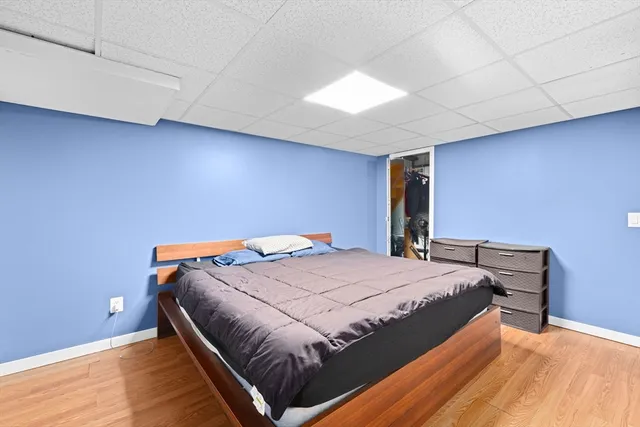 a bed sitting in a room next to a lamp