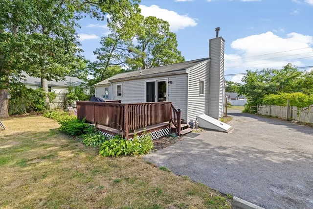a view of backyard with small cabin and wooden fence