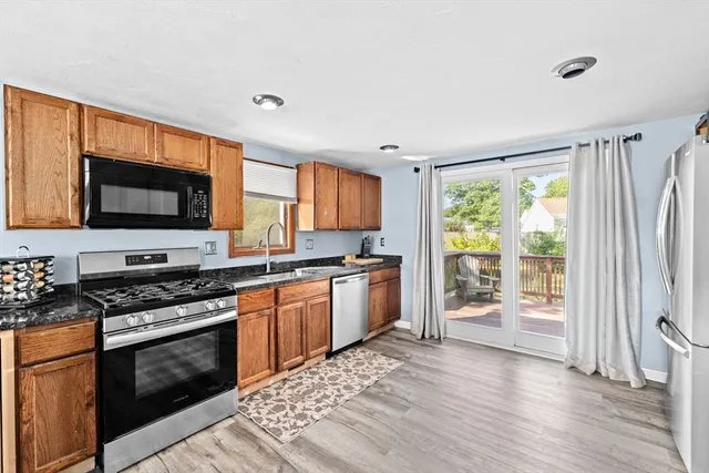 a kitchen with stainless steel appliances granite countertop a stove top oven a sink and a granite counter top