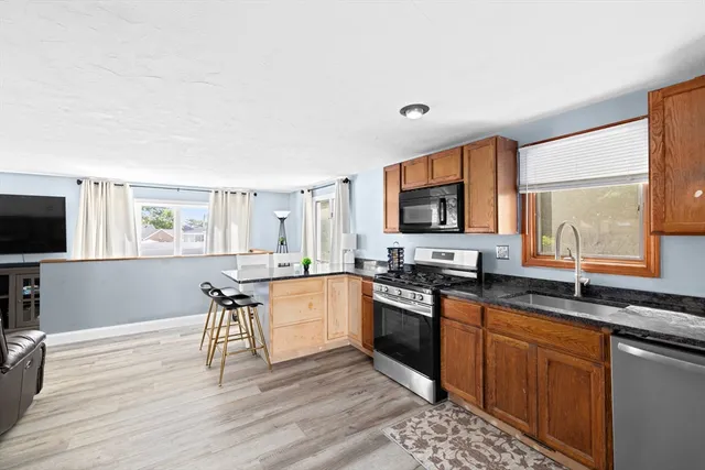 a kitchen with stainless steel appliances granite countertop a sink stove and wooden floor