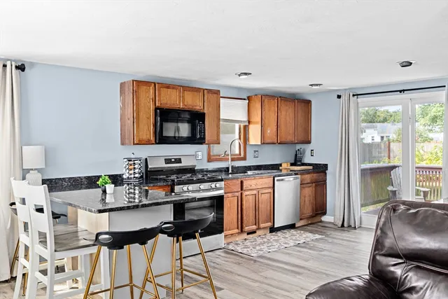 a kitchen with granite countertop a stove a sink and a refrigerator