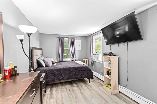 a bedroom with a bed and a flat tv screen on the table