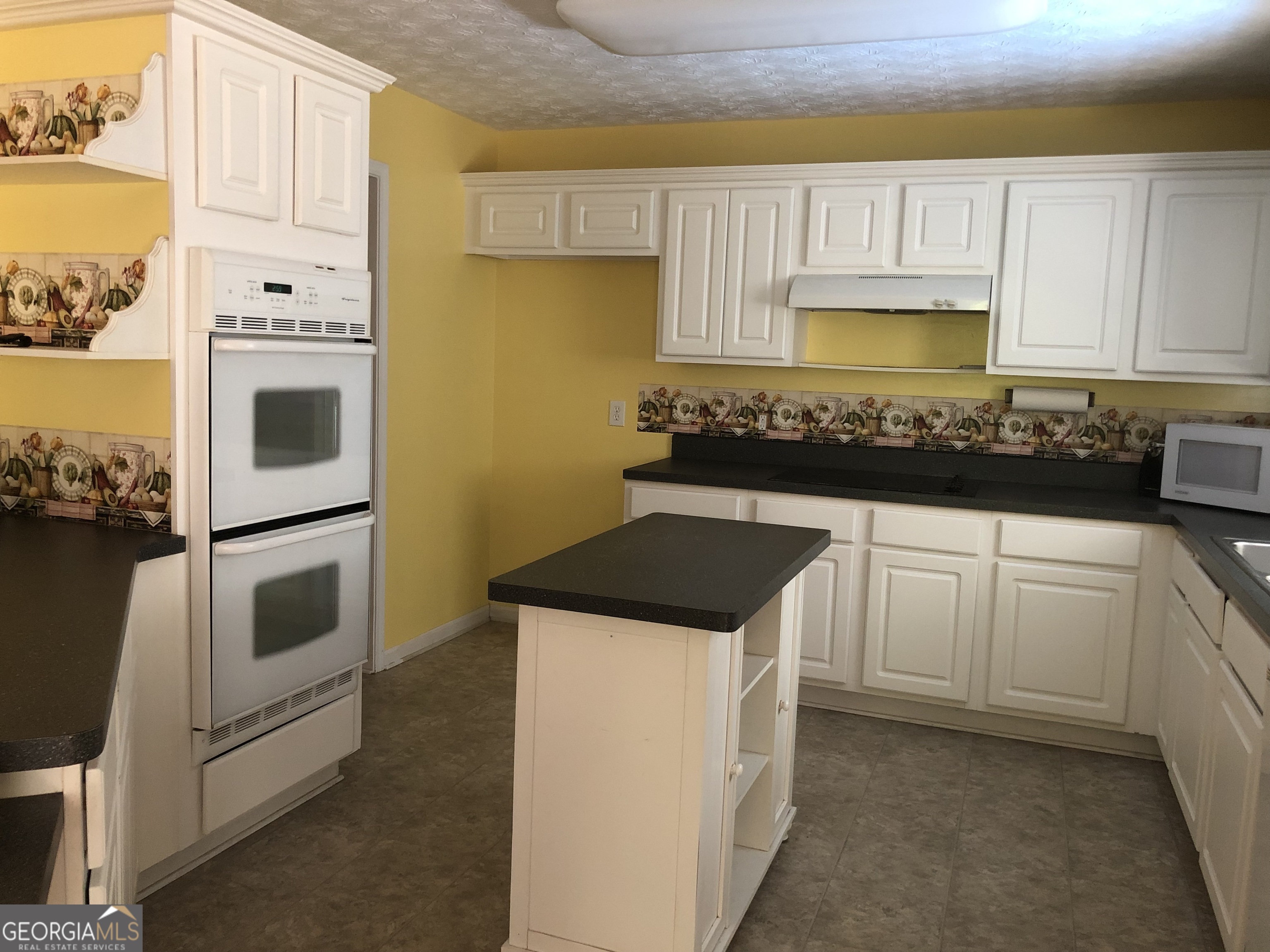 1744 Campbell Road Covington, GA 30014 - Photo 5 of 25 a kitchen with white cabinets and white appliances