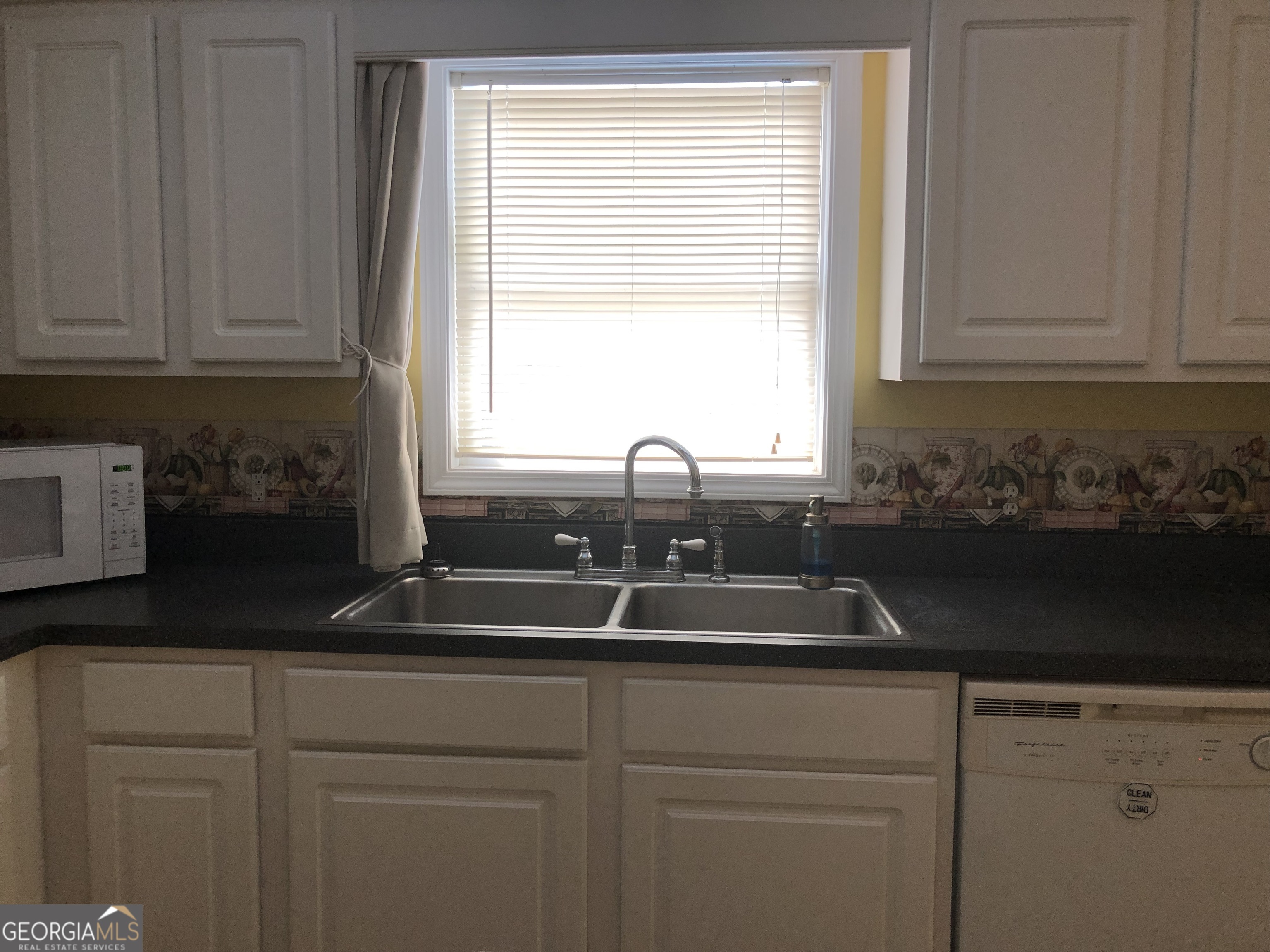 1744 Campbell Road Covington, GA 30014 - Photo 8 of 25 a kitchen with granite countertop white cabinets and a sink