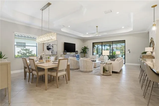 a view of a dining room and livingroom with furniture wooden floor a chandelier
