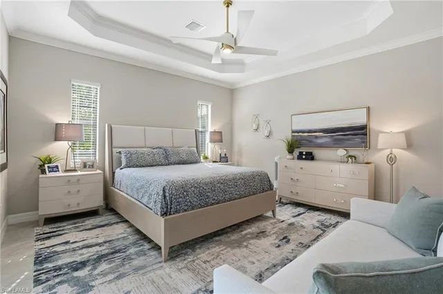a bedroom with a large bed and ceiling fan
