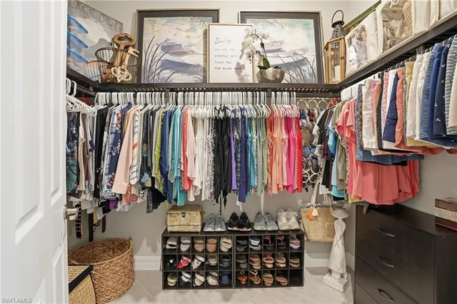 a view of walk in closet with clothes and shoes