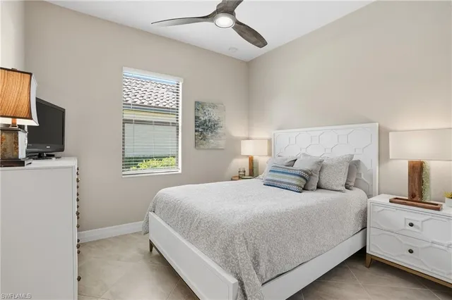 a bedroom with a bed and a flat tv screen on the dresser