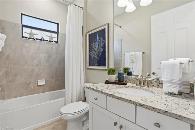 a bathroom with a granite countertop toilet a sink and a bathtub