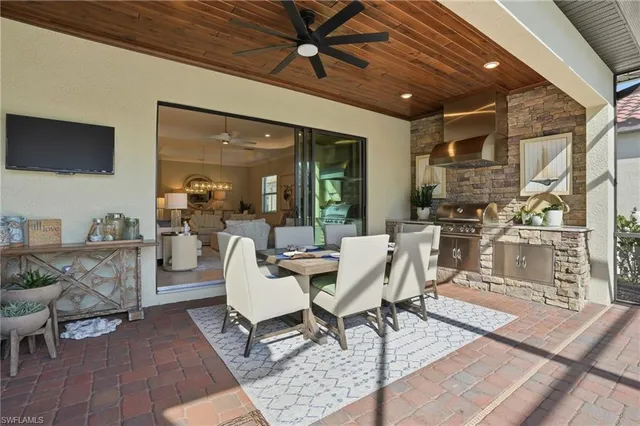 a dining room with furniture a rug a potted plant and a chandelier