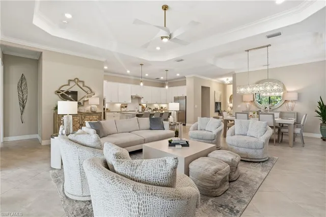 a living room with furniture kitchen view and a chandelier