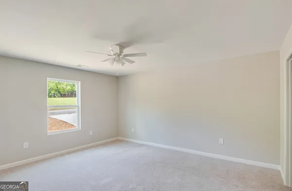 an empty room with a window and a fan