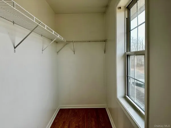 a view of a room with racks on the wall and a window