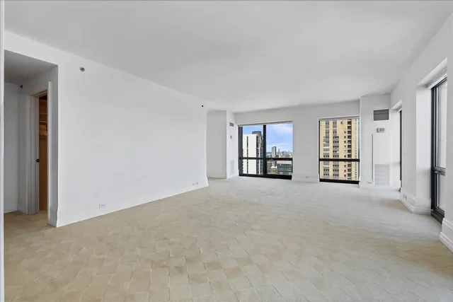 an empty room with floor to ceiling window and an outdoor view