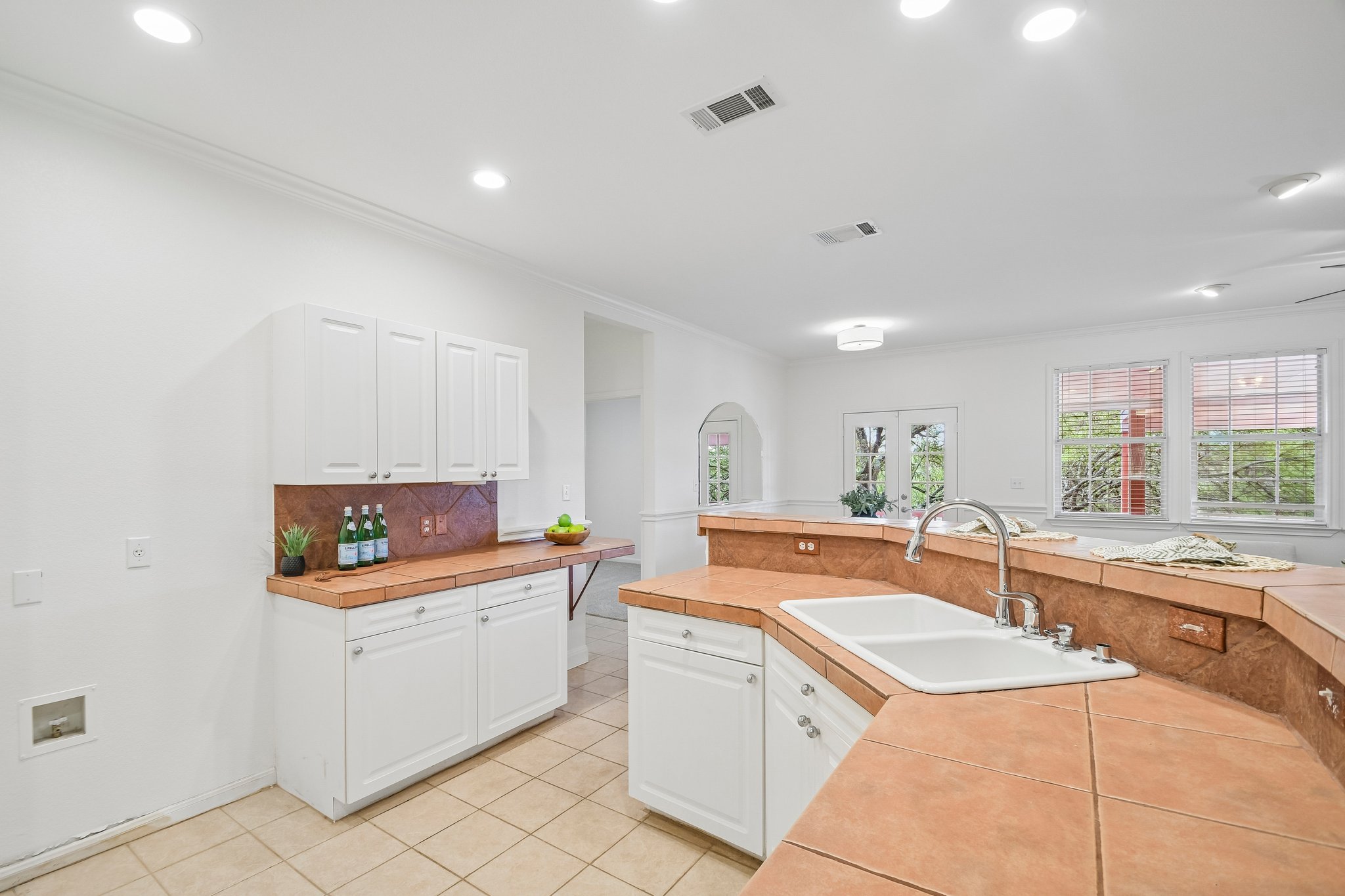 20609 Bridle Path Road Lago Vista, TX 78645 - Photo 14 of 30 A well-lit kitchen with terracotta tiled counters and crisp white cabinetry.