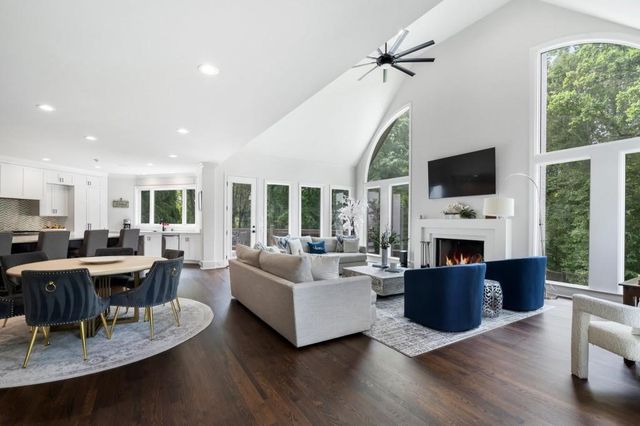 a living room with furniture a fireplace and a floor to ceiling window
