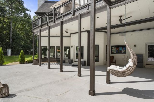 a view of a house with a big yard and a large tree