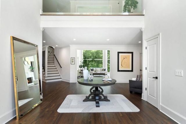 a living room with furniture and a large mirror next to a window