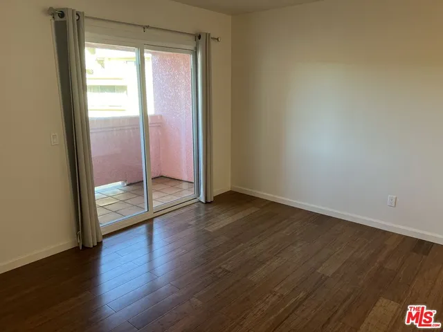 an empty room with wooden floor and door