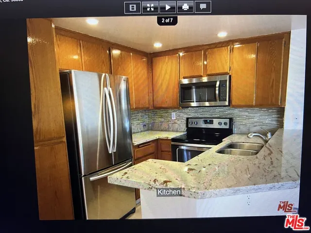 a kitchen with stainless steel appliances granite countertop a refrigerator a stove top oven a sink and dishwasher