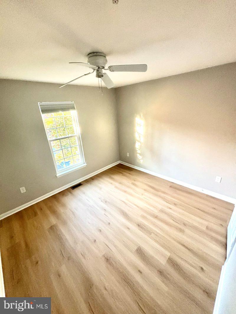 12411 Carters Grove Place Silver Spring, MD 20904 - Photo 8 of 11 an empty room with wooden floor chandelier fan and windows