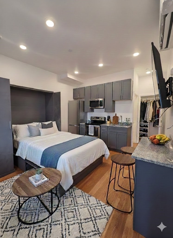 a bedroom with a bed a chair and potted plant on the table