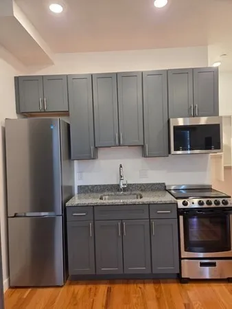 a kitchen with a sink a microwave a refrigerator and cabinets