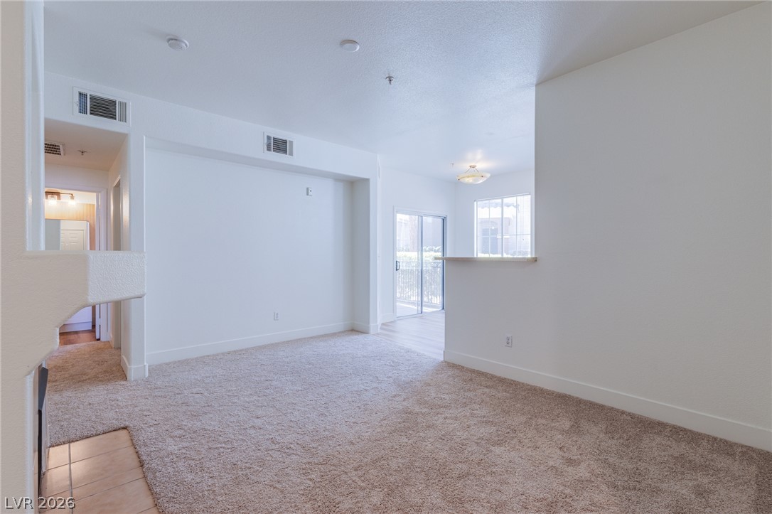 9050 West Warm Springs Road, Unit 1011 Las Vegas, NV 89148 - Photo 4 of 32 A spacious living area with plush carpeting and natural light offers comfort and versatility.