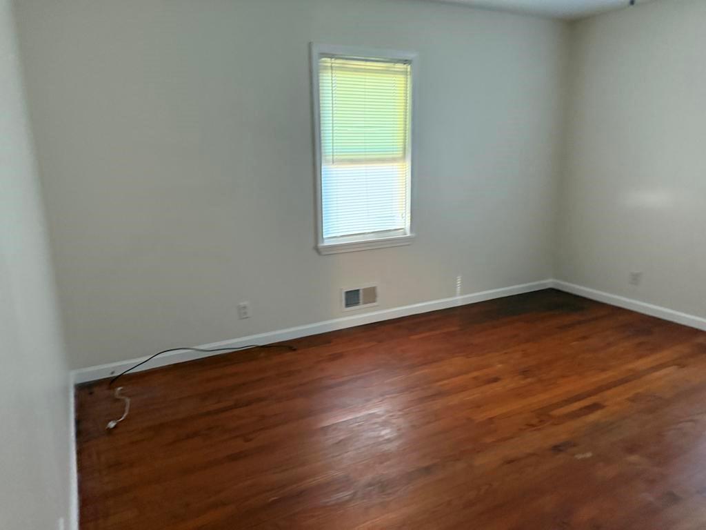 106 Flippen Road Stockbridge, GA 30281 - Photo 7 of 16 an empty room with wooden floor and a window