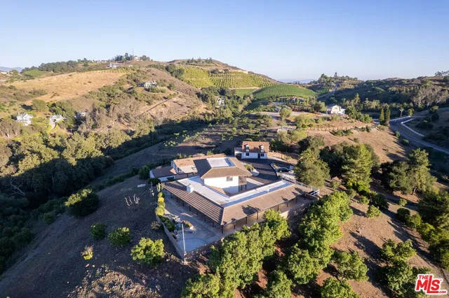 an aerial view of a house with a mountain