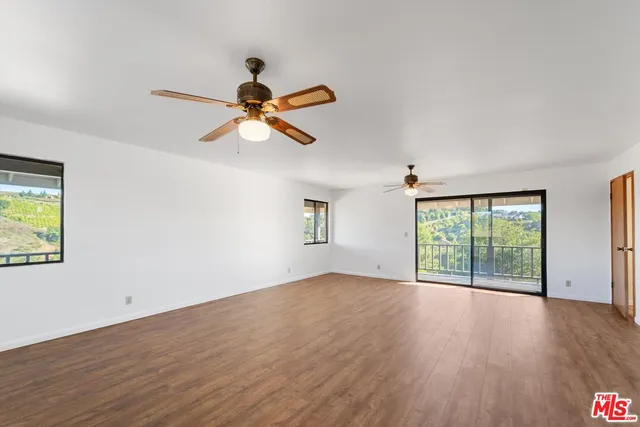 a view of room with window ceiling fan and wooden floor