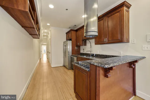 a kitchen with stainless steel appliances granite countertop a stove and a refrigerator