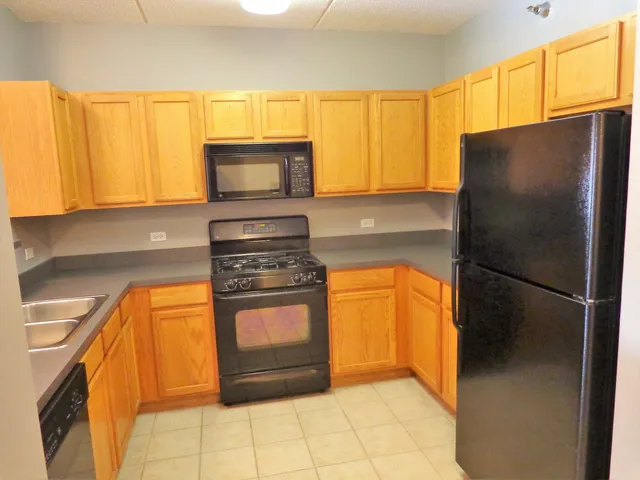 a kitchen with stainless steel appliances granite countertop a refrigerator a stove a sink and a microwave