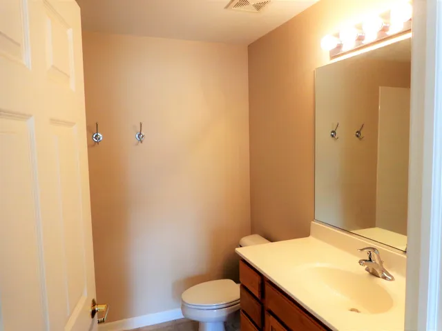 a bathroom with a granite countertop toilet and a sink