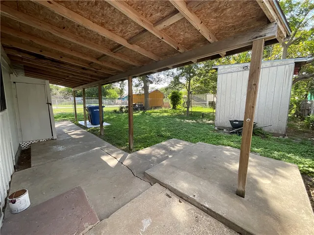 a view of a backyard with wooden fence and a porch