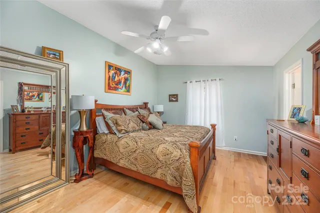 a bedroom with a bed and a mirror on dresser