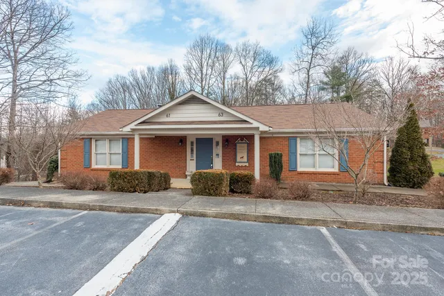 a view of a house with backyard and trees