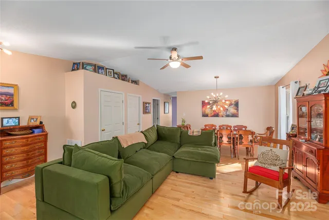 a dining room with furniture a chandelier and wooden floor