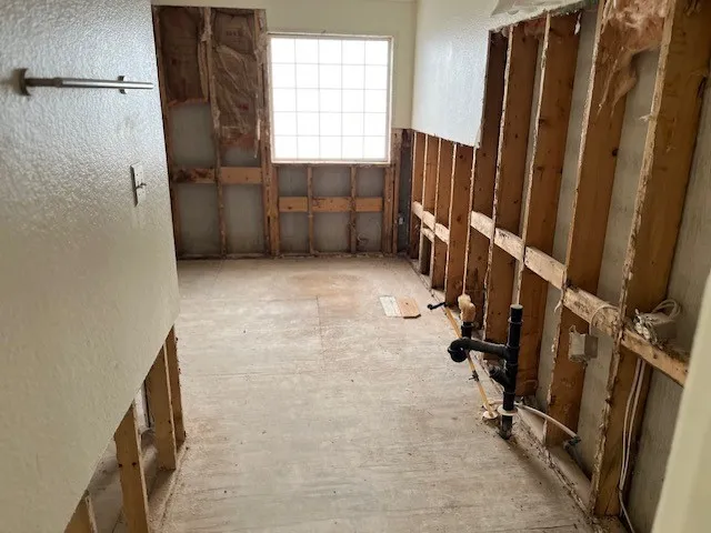 an empty room with a ceiling fan and windows