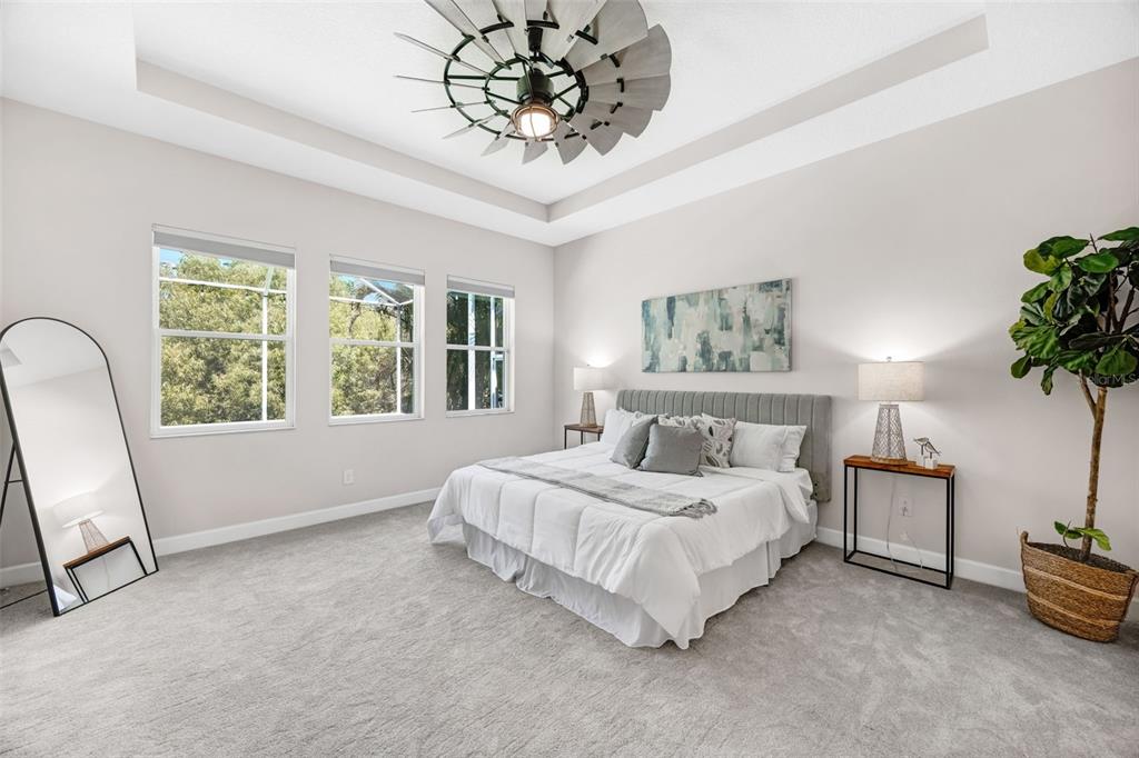 5116 Coastal Scene Drive Apollo Beach, FL 33572 - Photo 18 of 36 a bedroom with a large bed and a chandelier