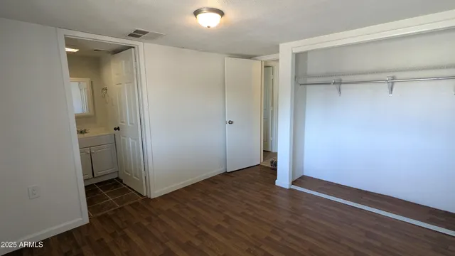 an empty room with wooden floor and a bathroom