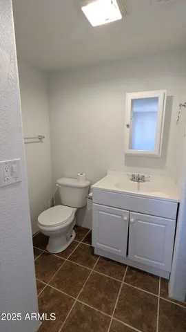a bathroom with a toilet a sink and mirror