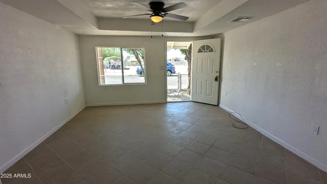 a view of a livingroom with a chandelier fan and windows